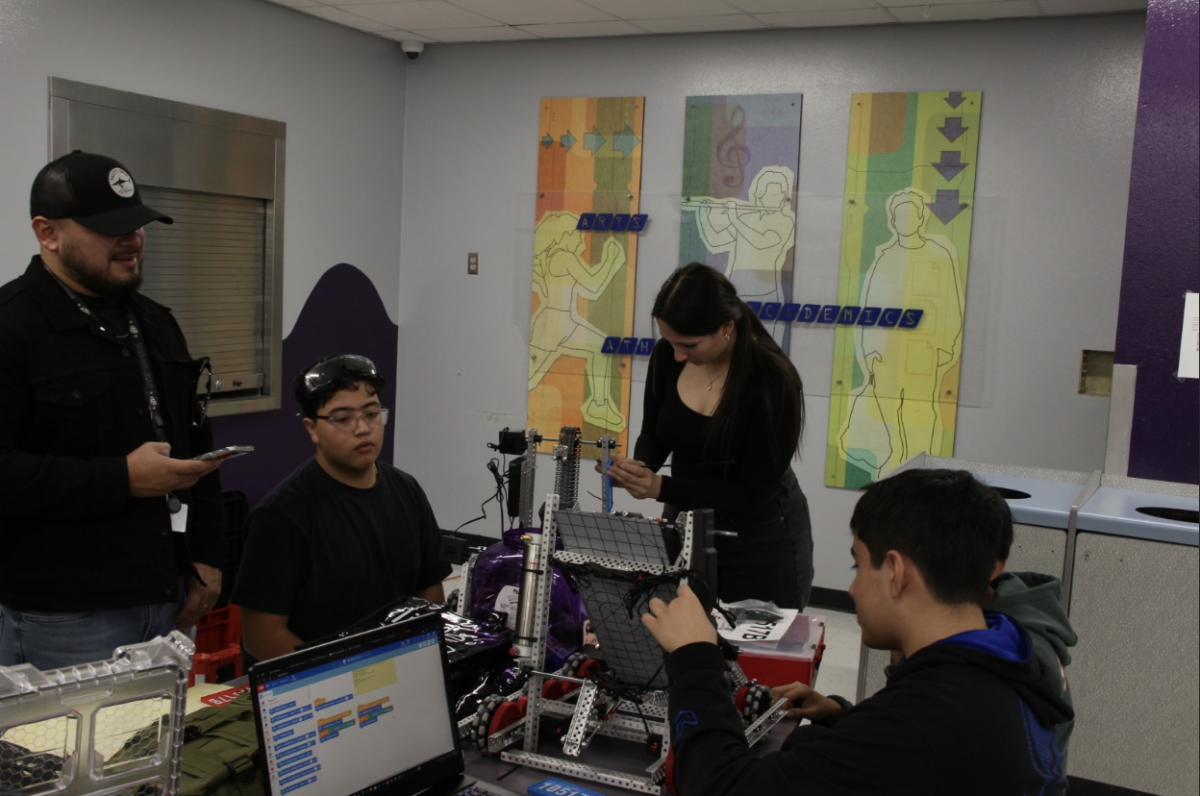 Robotics team from Ysleta work on and adjusts robot parts after their first matches. 